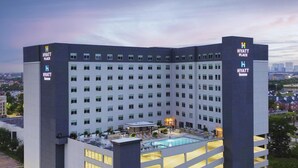 A multi-story hotel with a rooftop pool area, featuring a modern design and multiple balconies. - Hyatt Place Houston Medical Center (Houston)