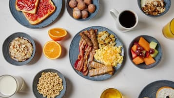 Un desayuno abundante con diferentes platos y bebidas sobre una mesa.