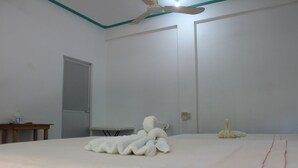 A room with a bed, a ceiling fan, a table, and a radiator. - Hotel Gamito (Puerto Escondido)