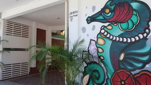 A building entrance with a mural of a seahorse. - Hotel Gamito (Puerto Escondido)