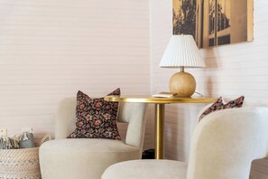 A cozy seating area with a round table, a lamp, and a decorative pillow. - Cozy Modern Suite in Fredericksburg (Fredericksburg)