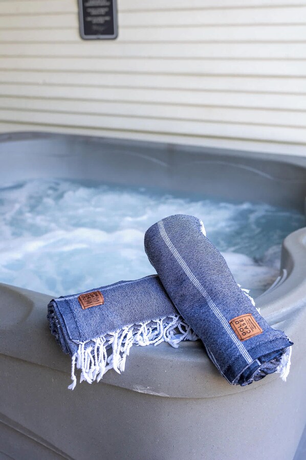 Un bain à remous avec deux serviettes en jean roulées posées sur le bord.
