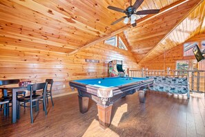 A wooden cabin with a pool table, chairs, and a ceiling fan. - Luxe Pool Cabin w/MTN views! Hot Tub + Theater (Pigeon Forge)