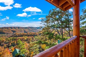 A wooden cabin with a view of a forested mountain range. - Luxe Pool Cabin w/MTN views! Hot Tub + Theater (Pigeon Forge)