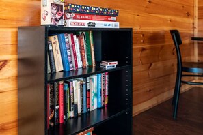 A bookshelf with various books and board games. - Luxe Pool Cabin w/MTN views! Hot Tub + Theater (Pigeon Forge)