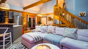 A cozy log cabin interior with a kitchen, dining area, and a staircase. - Cozy Cabin Inn w/ Private Hot Tub, Fire Pit + close to Golf, Trails, Waterfalls (Owen Sound)