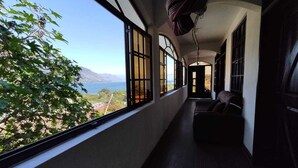 A corridor with large windows offering a view of a mountainous landscape.