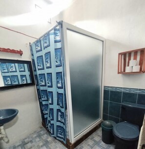 Un baño con cabina de ducha, lavabo e inodoro.