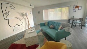 Un salon moderne avec un canapé, une table basse et un tapis.
