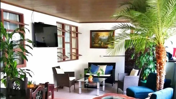 Un salon comprenant un téléviseur, une table à manger avec des chaises, un canapé et une table basse.
