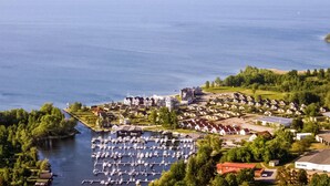 An aerial view of a coastal residential area with a marina, houses, and greenery. - 2 bedroom stunning home in Rechlin (Rechlin)