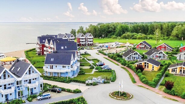 A coastal residential area with houses, a marina, and a clear view of the sea. - 2 bedroom stunning home in Rechlin (Rechlin)