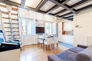 A modern living space with a dining area, kitchen, and a staircase. - [Old Town] - Corte D'Alba - Charming Suite (Alba)