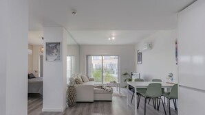 Eine moderne Wohnung mit Wohnbereich, Essplatz und Schlafzimmer.