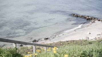 Enjoy a serene coastal view with a clear view of the shoreline and gentle waves lapping at the shore.