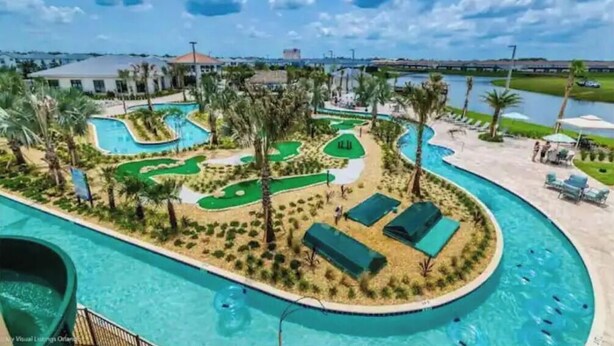 A resort with a large pool, a golf course, and a view of the surrounding area.