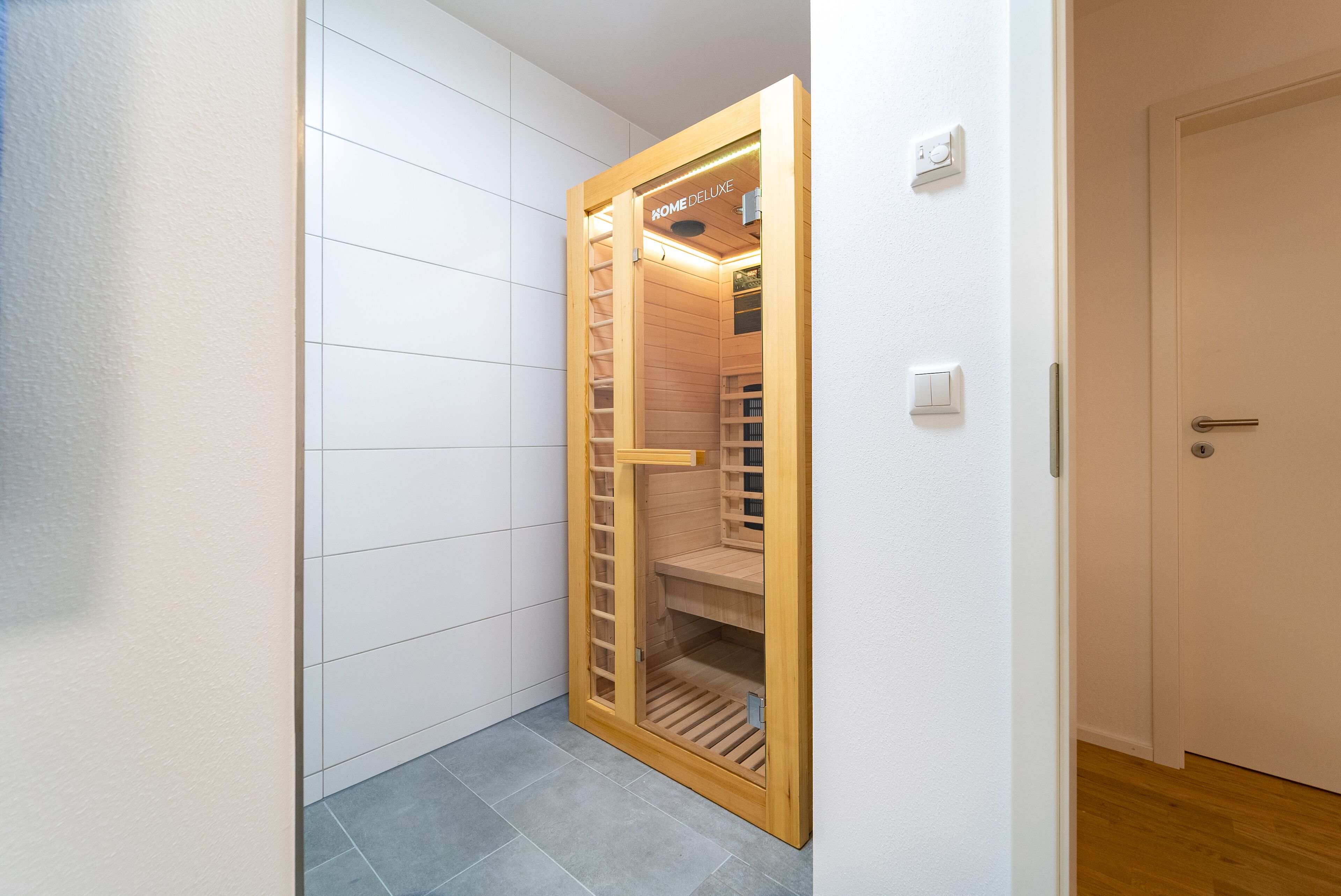 Ein schmaler Flur mit einem Holzschrank, der eine Schiebetür und Einbauregale hat.