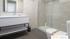 A modern bathroom with a glass shower enclosure, a white sink with a mirror, and a toilet. - Ref. 377638 (Motril)