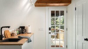 Een keuken met een houten aanrecht, een koffiezetapparaat en een spoelbak.