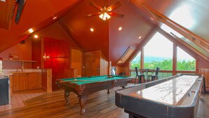 A pool table in a room with wooden floors and a sloped ceiling. - 9 Bedroom Estate, Sleeps 24, Pool, Hot Tub, Movie Theater, Game Room (Newry)
