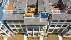Un immeuble résidentiel à plusieurs étages doté d’une cour intérieure aménagée avec du mobilier d’extérieur et un petit jardin.