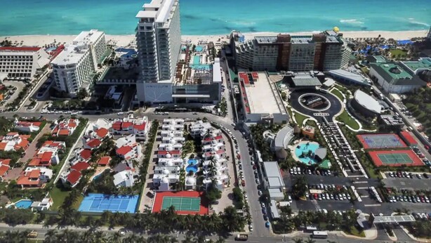 Un complexe hôtelier comprenant plusieurs bâtiments, une plage et un espace piscine.
