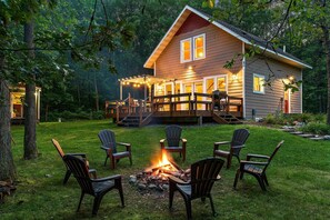 A cabin with a deck, a fire pit, and outdoor seating. - Peaceful and Cozy Modern Lakehouse Cabin on 4 acres (Outing)