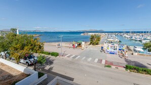 A marina with boats, a lighthouse, and a pedestrian walkway. - YourHouse Mulet, cozy sea-view apartment (Can Picafort)