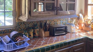 A kitchen with a wooden cabinet, a window, and a tiled backsplash. - Casa Fiesta, Best Place to Rest, 1 Block Away From the Beach Owner Managed (Rincón de Guayabitos)