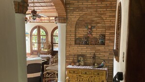 A traditional interior with brick walls, a wooden bench, and a tiled floor. - Casa Fiesta, Best Place to Rest, 1 Block Away From the Beach Owner Managed (Rincón de Guayabitos)