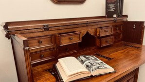 Uma mesa de madeira com livros abertos e um descanso para livros.