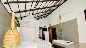 A bathroom with a large mirror, a bathtub, and a hanging light fixture. - Hotel Luna de Plata (Mahahual)