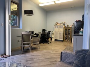 A room with a dining area, a kitchenette, and a seating area with a couch.