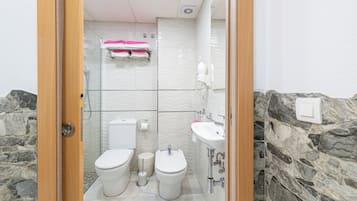 Een douche, een haardroger, een bidet, handdoeken