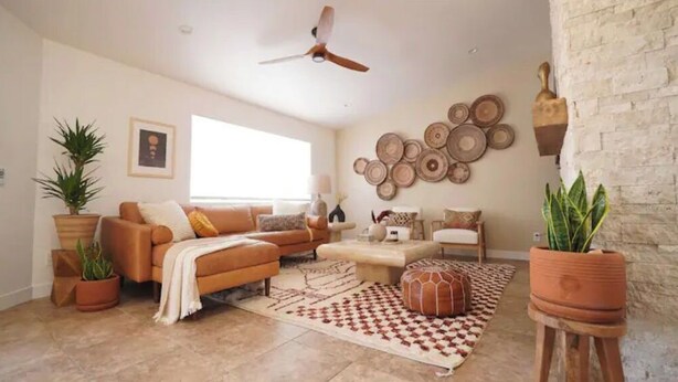 A living room with a sofa set, a coffee table, and a patterned rug. There are potted plants and wall decor. - Mystic Sky Ranch 5 Bedrooms with Yoga Studio & Spa (Landers)
