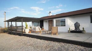 A single-story house with a covered patio area, a large cactus, and a statue. - Mystic Sky Ranch 5 Bedrooms with Yoga Studio & Spa (Landers)