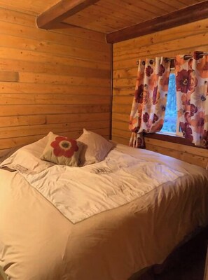 Cozy cabin retreat with a plush bed and floral accents.