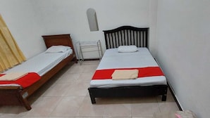 Een kamer met twee eenpersoonsbedden, een tafeltje en een radiator.