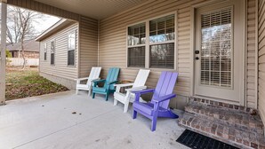 A covered porch with Adirondack chairs and a brick fireplace. - Back 40 Bike-In/Out, 3 Miles to Bike Park (Bella Vista)