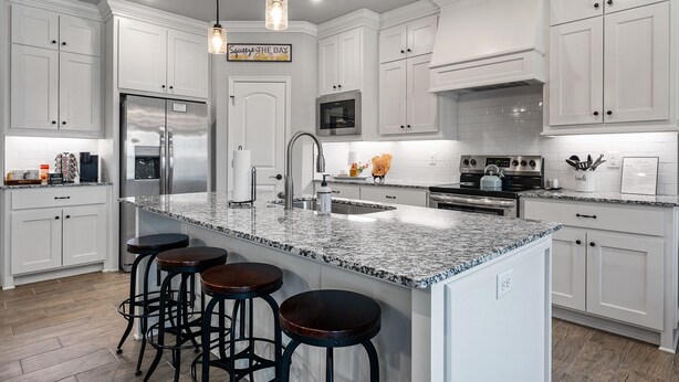 A modern kitchen with white cabinetry, a granite countertop, stainless steel appliances, and bar stools. - Back 40 Bike-In/Out, 3 Miles to Bike Park (Bella Vista)