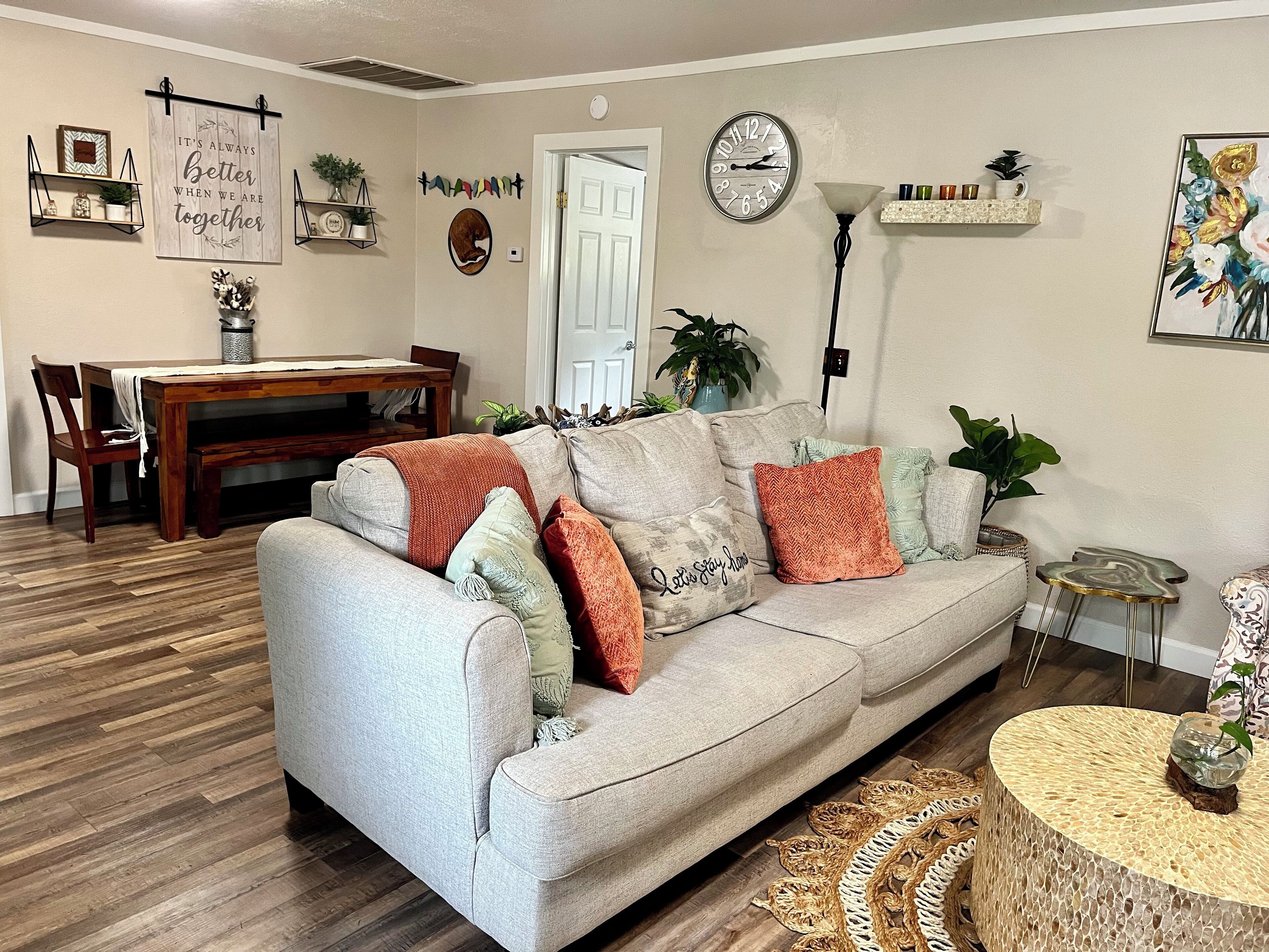 A living room with a sofa, coffee table, and a dining area with a table and chairs.