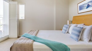 A hotel room with a bed, a window with blinds, a headboard, and a framed picture on the wall. - The Pool Resort - 1BR Pool View Haven (KINGSCLIFF)