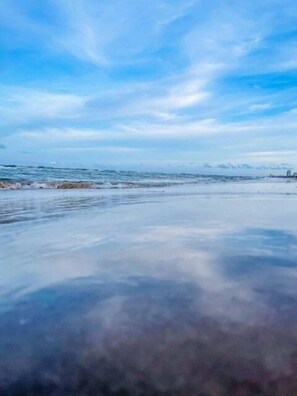 A beach with a clear sky and calm sea.