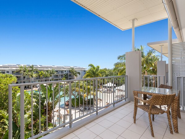 Ein Balkon mit Blick auf einen Pool und die Gebäude des Resorts.
