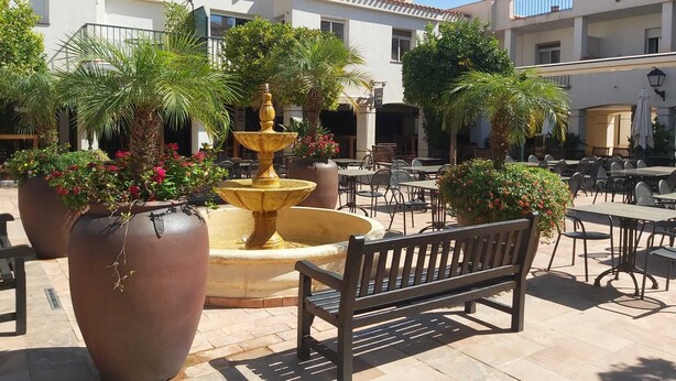An outdoor patio area with a fountain, seating, and potted plants. - 2 Bedroom Bellaluz Penthouse Apartment, La Manga Club (Cartagena)
