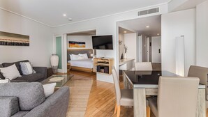 Una habitación de hotel moderna con sofá, cama, escritorio y televisor.