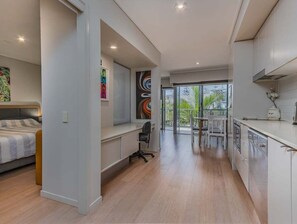 Un appartement moderne comprenant une cuisine, un coin repas et une chambre.