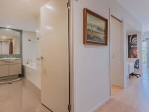 A modern bathroom with a sink, mirror, and tiled walls.