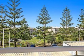 Stylish apartment buildings stand amidst well-manicured lawns and trees, offering a serene environment.