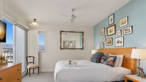 A bedroom with a bed, bedside table, chair, dresser, and a ceiling fan. - The Pool Resort Kingscliff - One Bed Ocean View (2308) - Holiday Management Co. (Tweed)